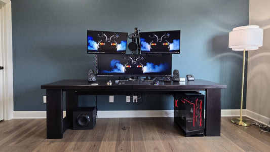 The finished Big Desk against a blue-gray wall, with three monitors on top and a PC tower under the right end